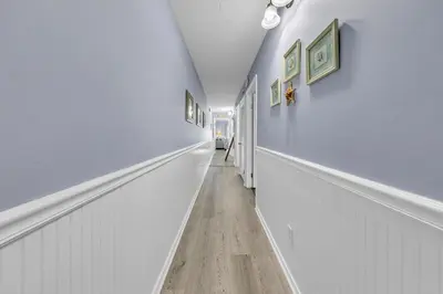 a hallway with white walls and a wooden floor at The Summit 928 in Panama City Beach