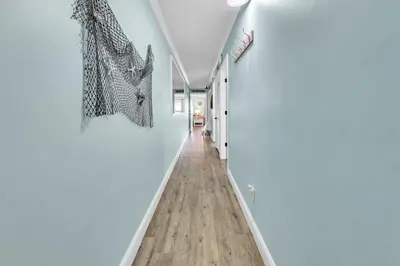 a hallway with white walls and a wooden floor at The Summit 924 in Panama City Beach