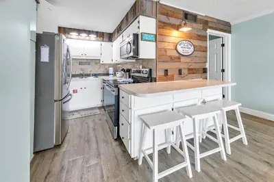 a kitchen with white appliances and wooden walls at The Summit 924 in Panama City Beach