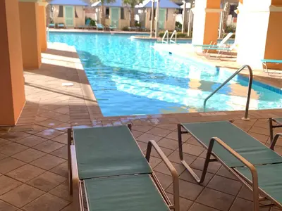 a swimming pool with two chairs in front of it at Sunset Cove at Calypso III in Panama City Beach