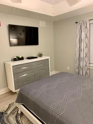 a bedroom with a bed and a tv on the wall at Sunset Cove at Calypso III in Panama City Beach