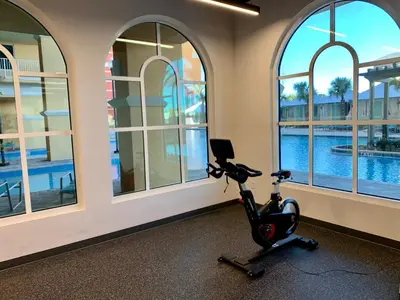 an exercise bike in a room with windows at Sunset Cove at Calypso III in Panama City Beach