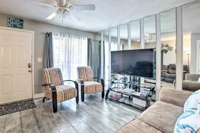 a living room with a flat screen tv and two chairs at Beautiful PCB Townhome Balcony and Resort Amenities in Panama City Beach