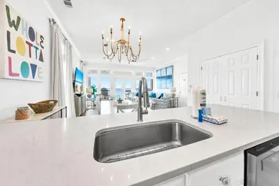 a kitchen with a stainless steel sink and white counter tops at Beach Love in Santa Rosa Beach