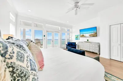 a bedroom with a large bed with a ceiling fan at Beach Love in Santa Rosa Beach