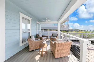 a porch with chairs and tables on a house at Beach Love in Santa Rosa Beach