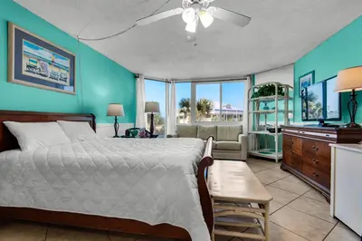 a bedroom with a bed and a living room at Top of the Gulf 210 in Panama City Beach