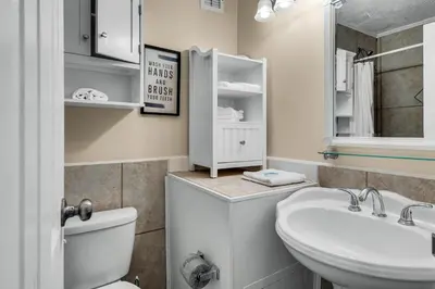 a bathroom with a sink and a toilet and a mirror at Top of the Gulf 210 in Panama City Beach