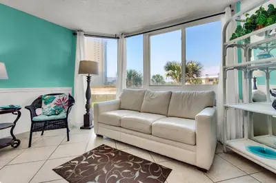 a living room with a white couch and windows at Top of the Gulf 210 in Panama City Beach