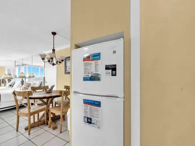 a kitchen and dining room with a white refrigerator at Top of the Gulf 610 in Panama City Beach