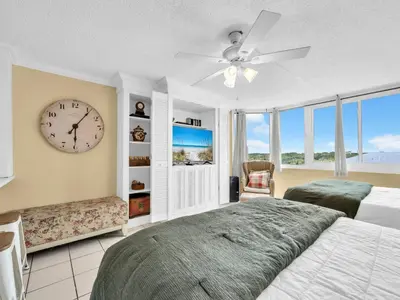 a bedroom with a bed and a clock on the wall at Top of the Gulf 610 in Panama City Beach