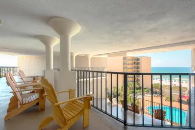 a balcony with chairs and a view of the beach at Top of the Gulf 610 in Panama City Beach