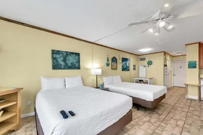 a hotel room with two beds and a ceiling fan at Top of the Gulf 822 in Panama City Beach