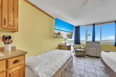 a bedroom with a bed and a desk and a chair at Top of the Gulf 822 in Panama City Beach
