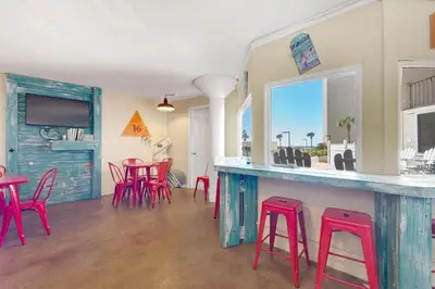 a room with a bar with red stools at Top of the Gulf 822 in Panama City Beach