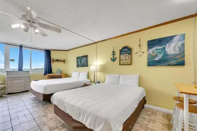 a hotel room with two beds and a ceiling fan at Top of the Gulf 822 in Panama City Beach