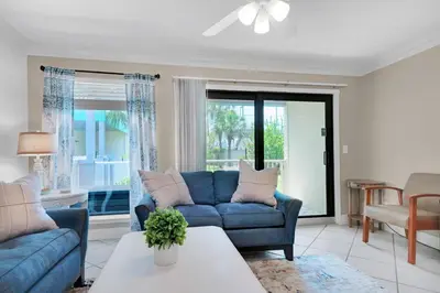 a living room with a blue couch and a table at Nautical Watch E-4 in Panama City Beach