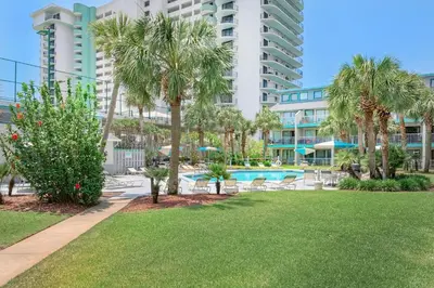 a resort with a pool and palm trees and buildings at Nautical Watch E-4 in Panama City Beach