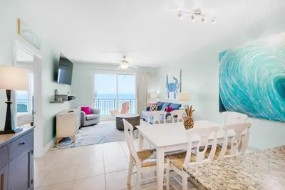 a dining room and living room with a table and chairs at Sterling Breeze 1401 in Panama City Beach
