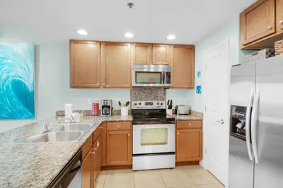a kitchen with a stove and a sink and a refrigerator at Sterling Breeze 1401 in Panama City Beach