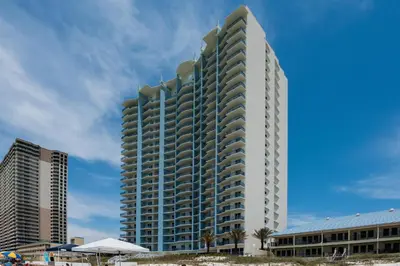 a tall white building on the beach with buildings at Sterling Breeze 1401 in Panama City Beach