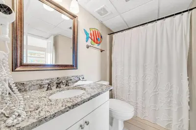 a bathroom with a sink and a toilet and a mirror at Edgewater Tower 2-1208 in Panama City Beach