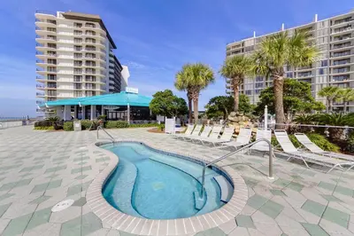 a swimming pool in a resort with palm trees and buildings at Edgewater Tower 2-1208 in Panama City Beach