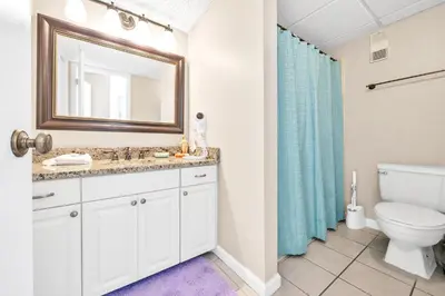 a bathroom with a sink and a toilet and a mirror at Edgewater Tower 2-1208 in Panama City Beach
