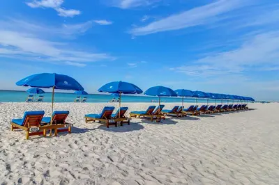 a row of blue umbrellas and chairs on a beach at Edgewater Tower 2-1208 in Panama City Beach