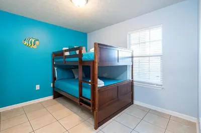 a bedroom with two bunk beds in a room with blue walls at PALM COVE VACATION HOME- One level, Community pool, Pet Friendly in Panama City Beach