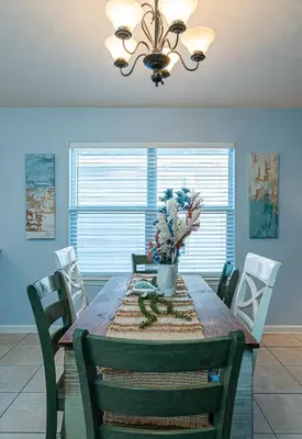 a dining room table with chairs and a chandelier at PALM COVE VACATION HOME- One level, Community pool, Pet Friendly in Panama City Beach