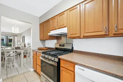 a kitchen with wooden cabinets and a stove top oven at Beachwalk Resort by Panhandle Getaways in Panama City Beach