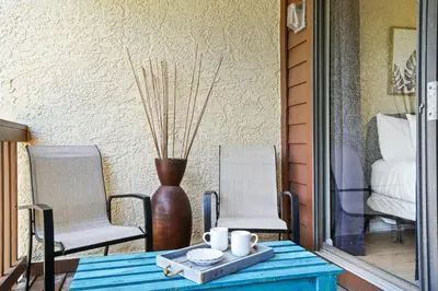 a blue table and chairs on a porch with a vase at Beachwalk Resort by Panhandle Getaways in Panama City Beach
