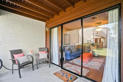 a patio with a couch and a table and chairs at Beachwalk Resort by Panhandle Getaways in Panama City Beach