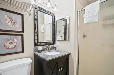a bathroom with a sink and a mirror at Beachwalk Resort by Panhandle Getaways in Panama City Beach