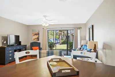 a living room with a dining room table and a living room at Beachwalk Resort by Panhandle Getaways in Panama City Beach