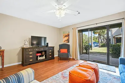 a living room with a tv and a couch and a chair at Beachwalk Resort by Panhandle Getaways in Panama City Beach