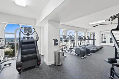 a gym with treadmills and ellipticals in a building at Calypso Beach Resort & Towers by Panhandle Getaways in Panama City Beach