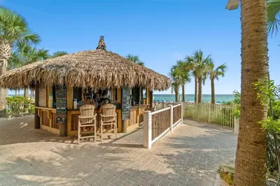 aiki bar on the beach with palm trees and the ocean at Calypso Beach Resort & Towers by Panhandle Getaways in Panama City Beach