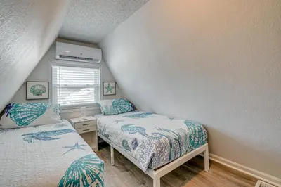 a small bedroom with two beds and a window at Cozy 3BRand3BA • Sleeps 9 • 0 3 Mi to Beach • PCB in Panama City Beach