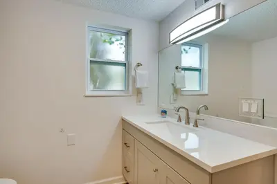 a bathroom with a sink and a mirror at Cozy 3BRand3BA • Sleeps 9 • 0 3 Mi to Beach • PCB in Panama City Beach