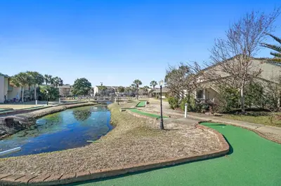 a park with a pool of water and trees at Gulf Highland Rentals by Panhandle Getaways in Panama City Beach