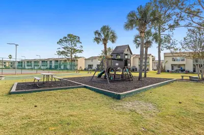 a park with a playground with a swing at Gulf Highland Rentals by Panhandle Getaways in Panama City Beach