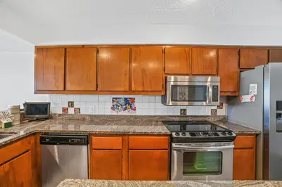 a kitchen with wooden cabinets and stainless steel appliances at Seaward Townhome Rentals by Panhandle Getaways in Panama City Beach
