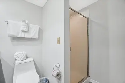 a white bathroom with a shower and a toilet at Seaward Townhome Rentals by Panhandle Getaways in Panama City Beach