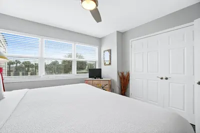 a white bedroom with a bed and a window at Seaward Townhome Rentals by Panhandle Getaways in Panama City Beach