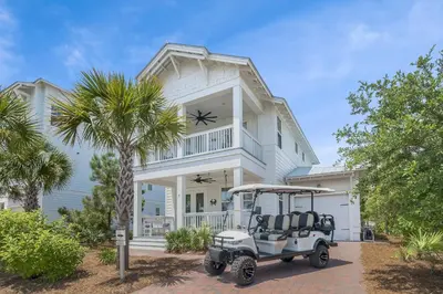 a golf cart parked in front of a house at Crab Cottage in Inlet Beach