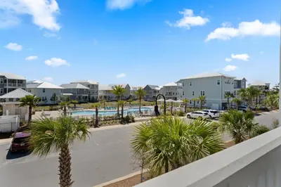 a view of a parking lot with palm trees and condos at Crab Cottage in Inlet Beach
