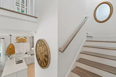 a white staircase with a clock on the wall at Crab Cottage in Inlet Beach