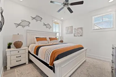 a bedroom with a bed and a ceiling fan at Crab Cottage in Inlet Beach